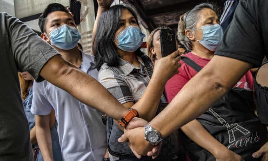 People wear face masks in Manila