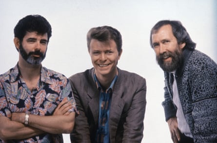 Three men stand laughing at the camera.
