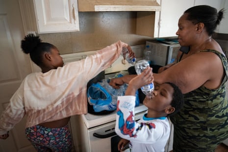 A boy drinks water, a girl and grandmother boil water