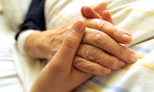 An older woman's hand being held