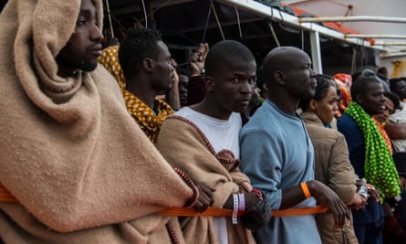 Refugees wait on the deck of a Spanish vessel after being rescued off the Libyan coast in February.