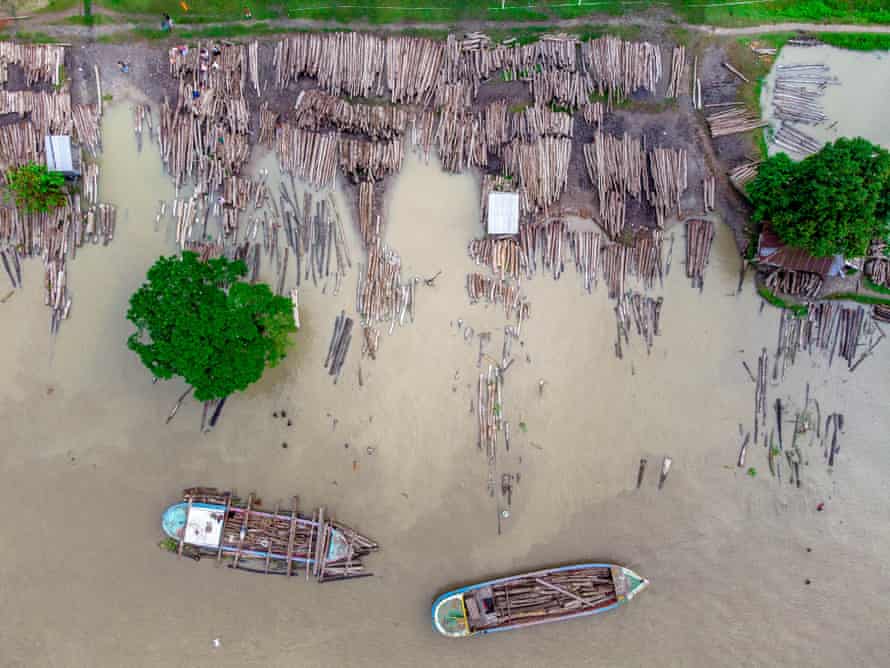 Aerial photo of a timber market with  hundreds of logs floating on a river