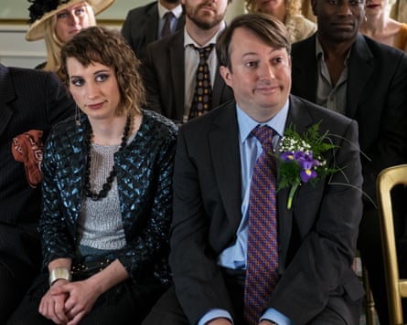Woman and man sit in chairs at a wedding