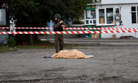 The body of one of the victims lies covered by a blanket