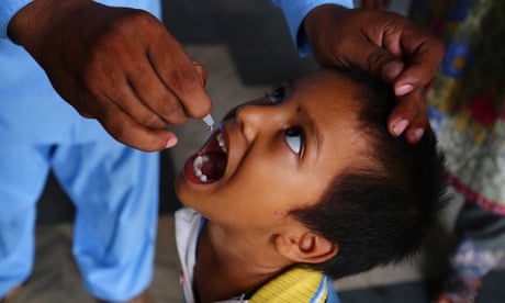 A health worker administers a polio vaccination to a child, in Karachi, Pakistan