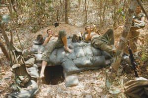 Two US troops from the 1st Air Cavalry relax on top of a bunker while stationed at a blocking position north of the Michelin Plantation, Vietnam, 1969