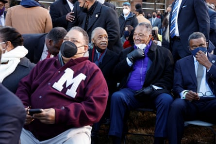 Al Sharpton and Jesse Jackson sit among a crowd of masked attendees