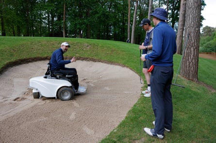 Kris Aves, an ex-police officer who was paralysed in the 2017 Westminster Bridge terror attack, has trouble getting his Paragolfer to his ball in a steep bunker by the 16th green and gets a ruling from an R&A referee