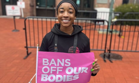 Takira Walker, 19, stands with a sign at the women's march, on the 50th anniversary of Roe vs Wade.