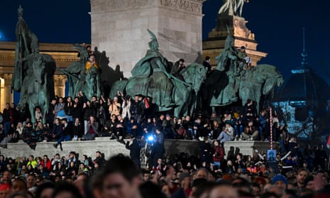 Big crowd standing in square and on horse sculptures a protest at Heroes' Square in Budapest