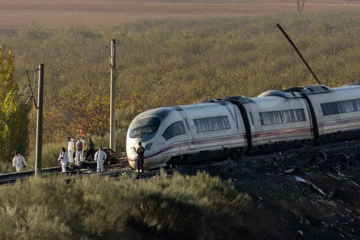 Officials standing on tracks in front of a train.