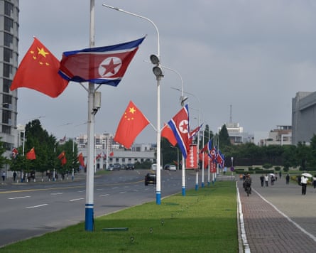 flags of China and North Korea decorate lamp-posts in a street in Pyongyang