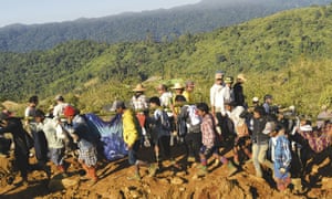Jade mine workers and rescue teams carry victims of the landslide in Hpakant, Myanmar.