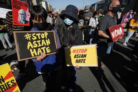 person holding signs saying ‘stop Asian hate’
