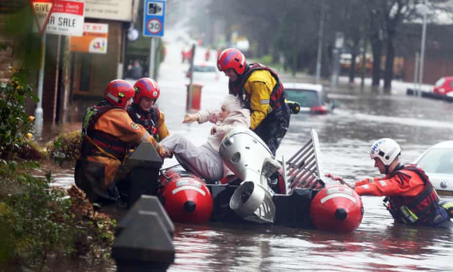 Fire and rescue services evacuate a woman from her flooded home in Littleborough, Greater Manchester