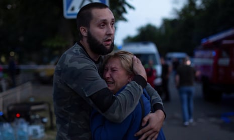 People react at the site of a restaurant building heavily damaged by a Russian missile strike.