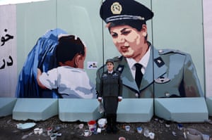 Kabul, Afghanistan Friba Hameed, 30, an Afghan police officer, poses for a photograph in front of a mural of herself, painted by an independent artist, outside the main gate of a police precinct