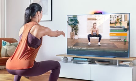 A woman exercising using the Sky Live camera and Mvment fitness app on a Glass TV.