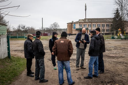 Roman Avramenko, executive director of the NGO Truth Hounds, and Yarapolk Brynykh, a board member of Truth Hounds, speak to people in Stara Basan village as they investigate war crimes.