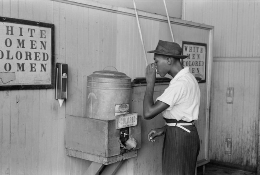 A man drinking at a ‘colored’ water cooler at a bus terminal in Oklahoma City in July 1939.