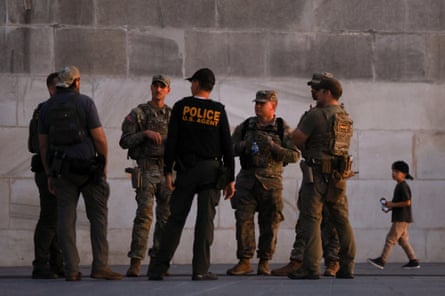 group of people in uniform stand next to grey wall