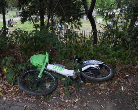 A Lime bike lying on its side on the pavement