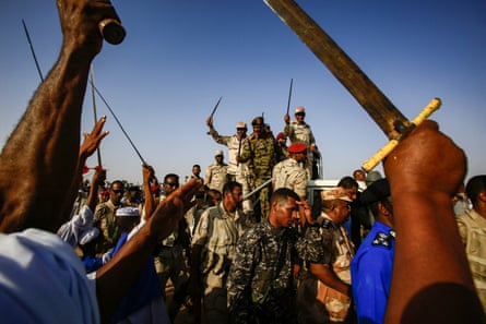 Mohamed Hamdan Daglo, also known as Hemeti, deputy head of Sudan’s ruling Transitional Military Council and commander of the Rapid Support Forces paramilitaries, waves a baton as he rides in the back of a vehicle surrounded by RSF members.
