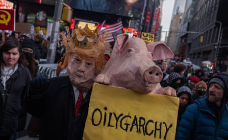 Protester in a Donald Trump mask holding a pig's head with a sign that reads,