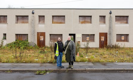 Two residents outside derelict houses