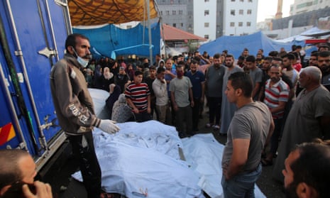 People surround the bodies of people killed a day earlier in an Israeli strike that hit the Al-Shifa hospital in Gaza City, during a funeral for the victims on 4 November.