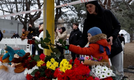 A woman and a child leave tributes near the site. The victims from the attack included a 15-year-old girl, President Volodymyr Zelenskiy said in his latest nightly address