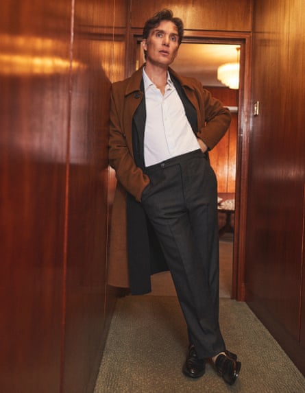 Actor Cillian Murphy leaning against a wooden wall in a hallway