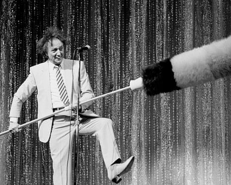Ken Dodd holding an enormous tickling stick on the stage of the London Palladium 1990.