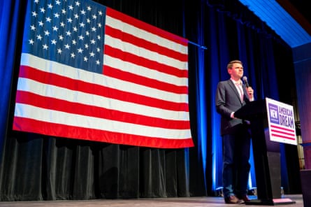 a man in front of a flag