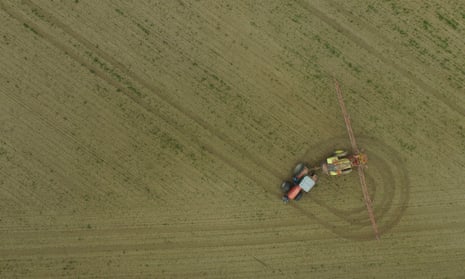 A tractor spreads pesticide on a field near Prenzlau, Germany