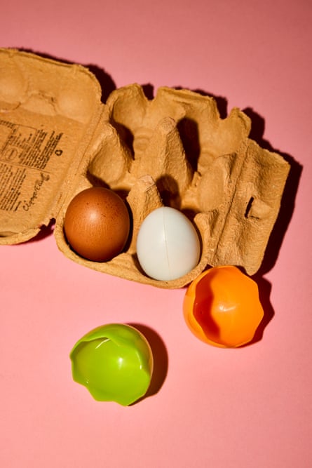 Egg box with two eggs and plastic shells beside it
