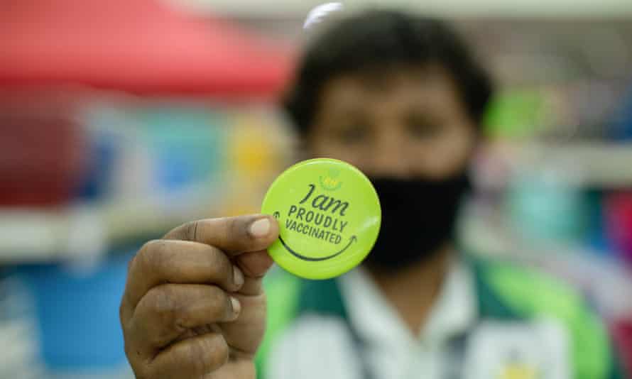 A Port Moresby worker with a badge showing his vaccination status