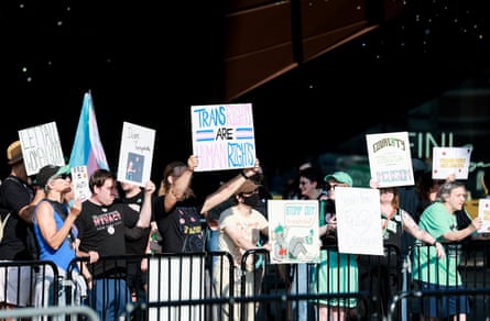 people hold signs in support of transgender people