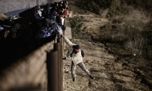 A person jumps a border fence to get into San Diego, California from Tijuana, Mexico on 1 January.