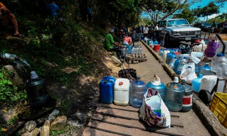 People gather to collect water in Caracas on Sunday.