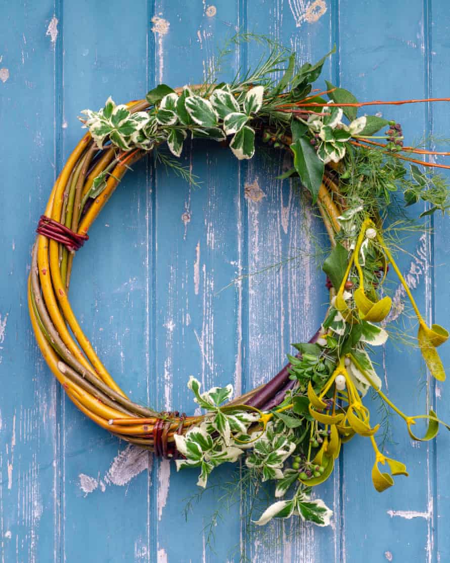 Handmade Christmas wreath made from hedgerow materials hanging on a blue door