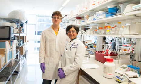 eric minikel and sonia vallabh in lab coats at a work bench in the broad institute