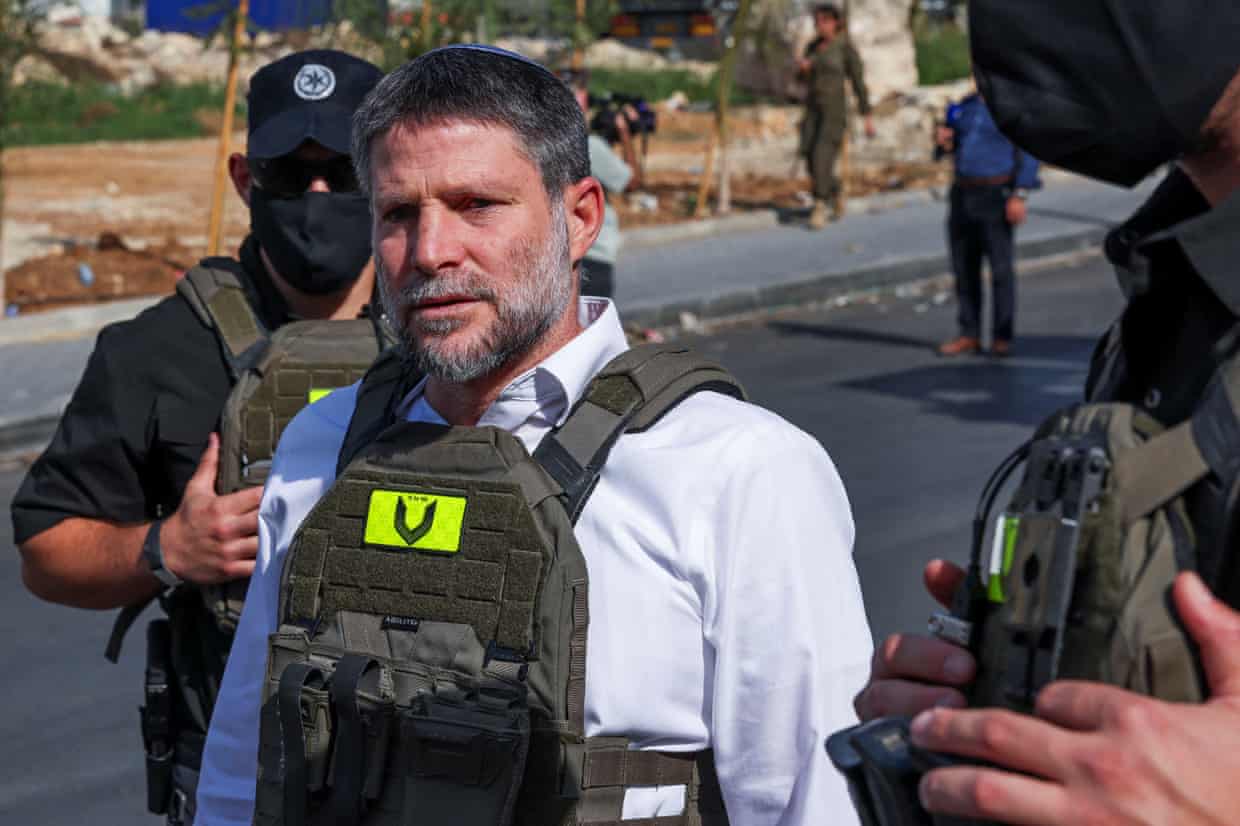 Israel's Finance Minister Bezalel Smotrich, wearing body armour, is escorted by armed guards