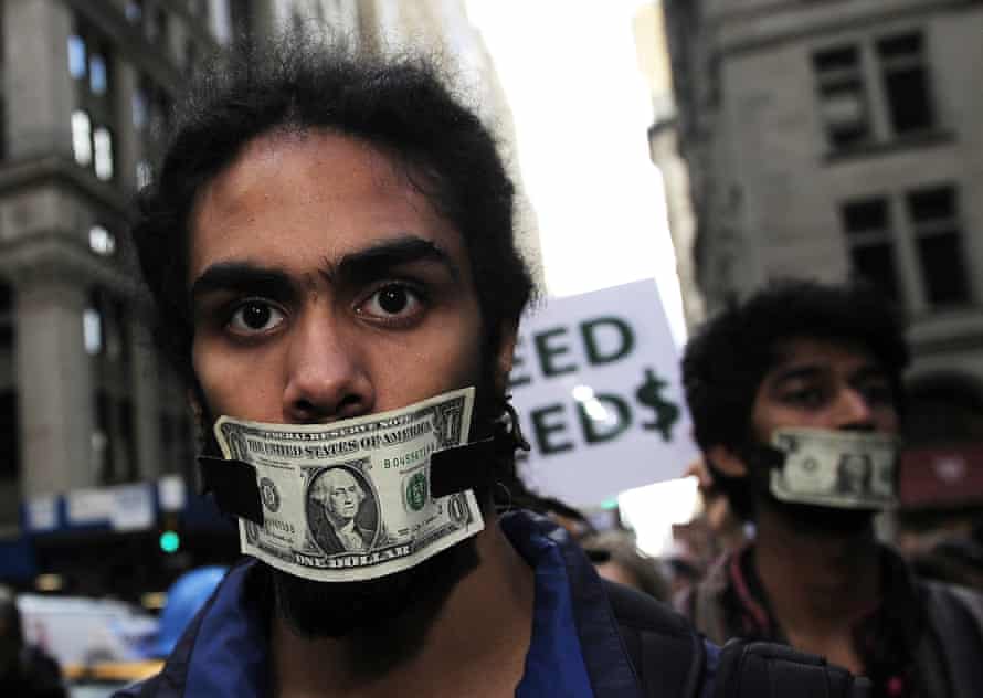 Head shot of an Occupy Wall Street protester in New York, October 2011, with a dollar bill taped across his mouth