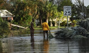People walk through flooded streets the morning after Hurricane Irma swept through Fort Myers, Florida.