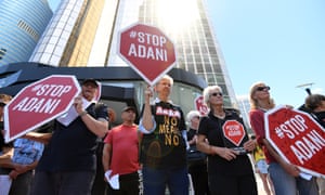 Anti-Adani protesters hold signs outside the company’s offices in Brisbane