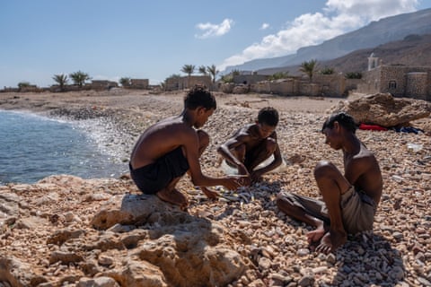 Boys check their catch on the beach