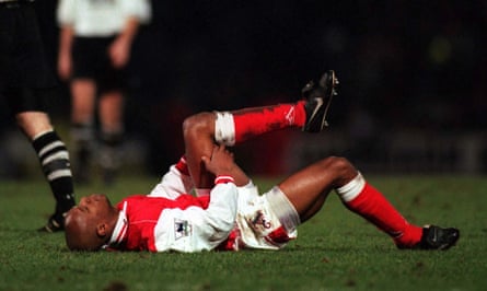 Ian Wright on his back, holding his left leg