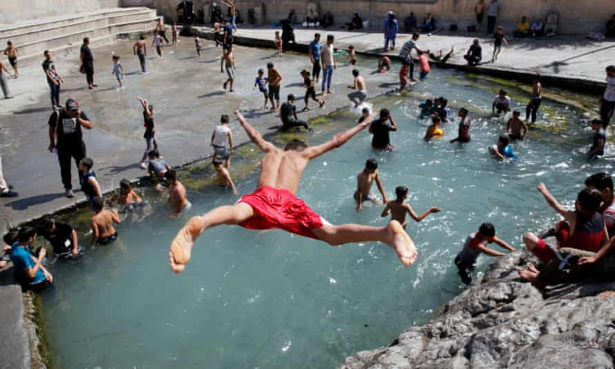 An Iranian boy jumps at the Cheshme-Ali pool located in the city of Shahre-Ray, southern of Tehran, Iran, during a heatwave on 19 June 2020.