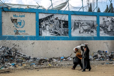 People walk past Unrwa’s damaged Gaza City headquarters